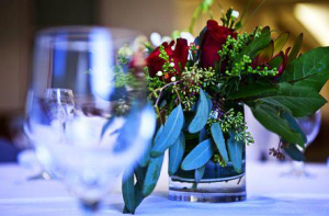 Blurred empty wine glass with focus on roses centerpiece